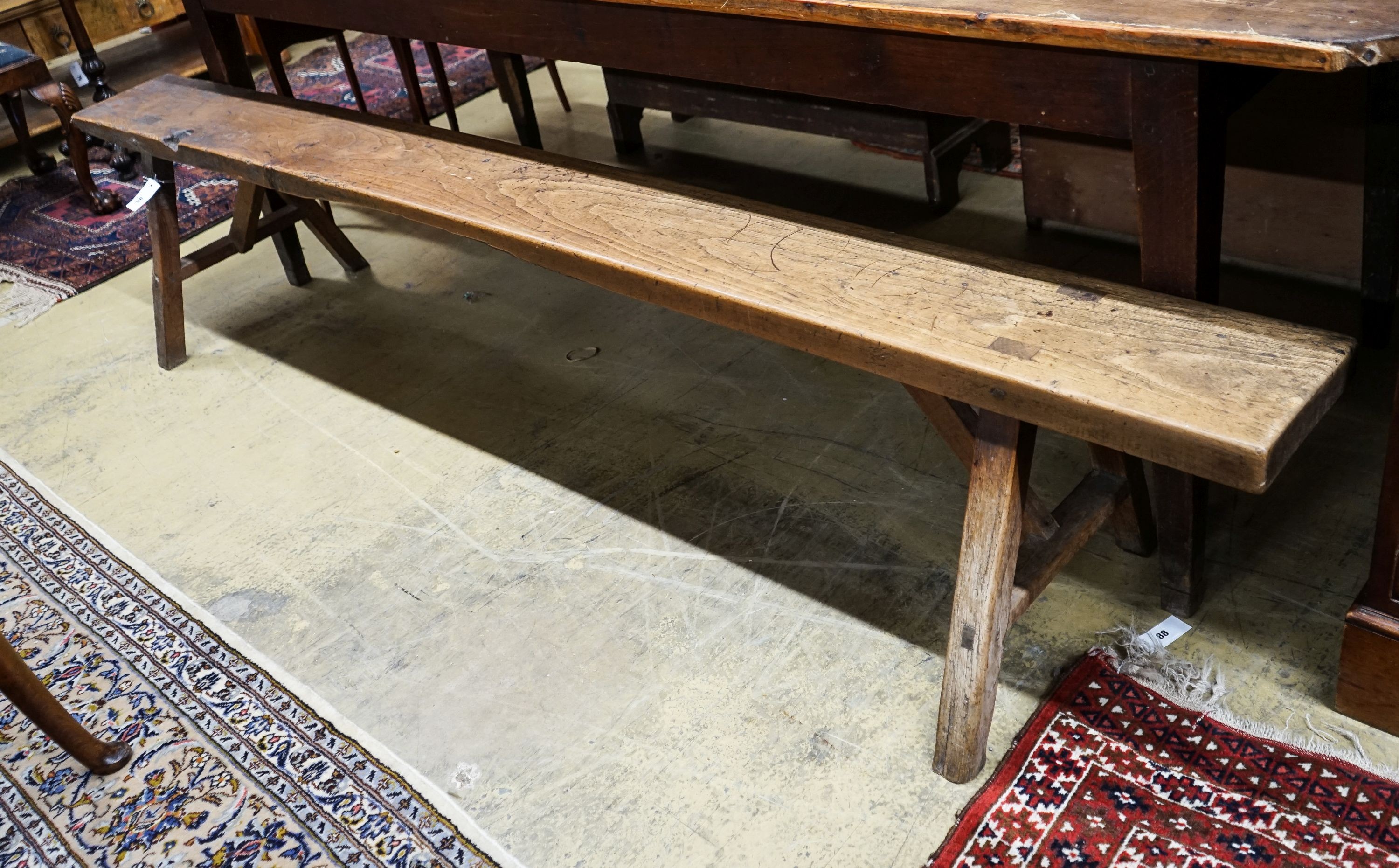 A 19th century French provincial cherry bench seat, length 242cm, depth 46cm, height 46cm